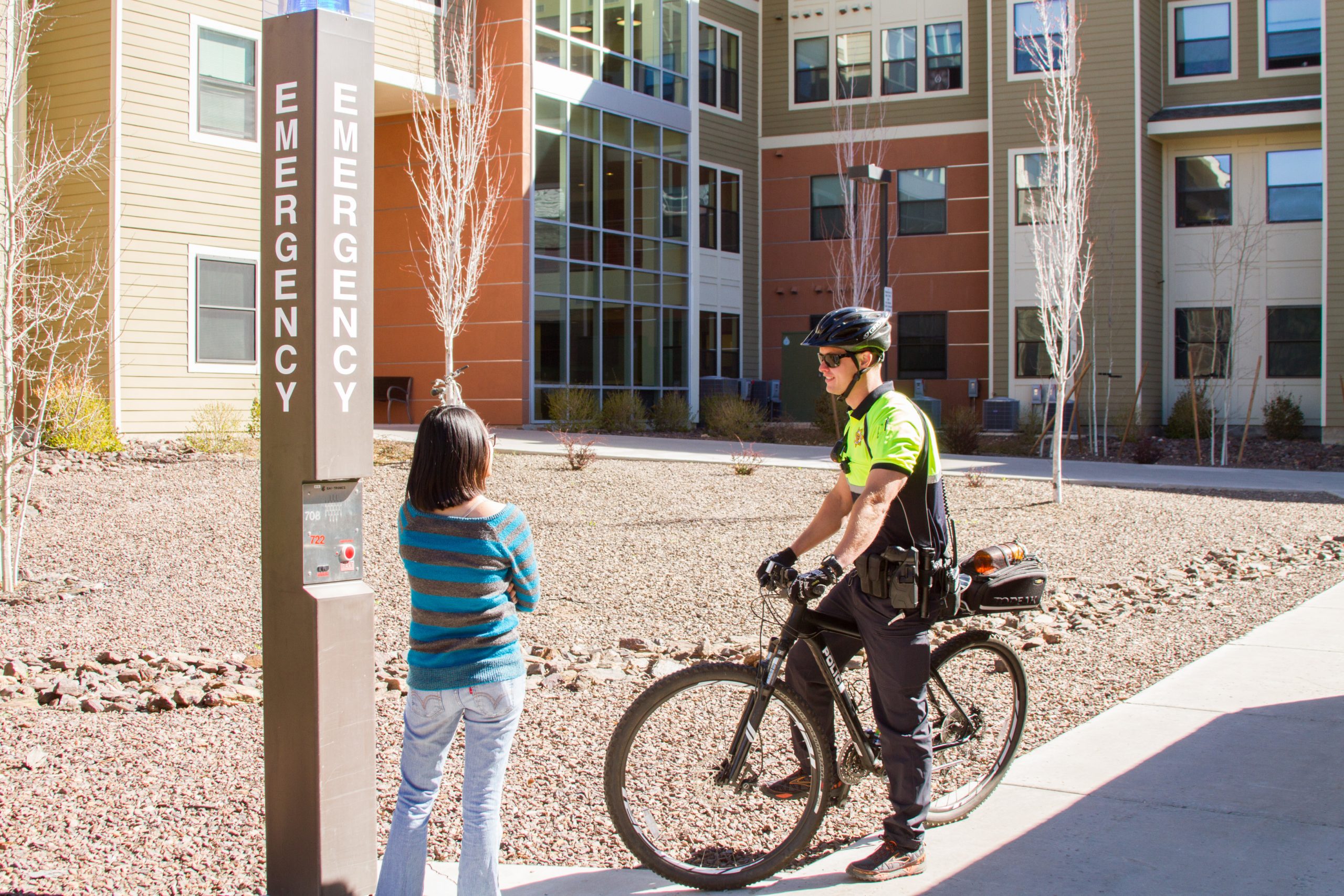 Campus police officer on bike talks to a student.