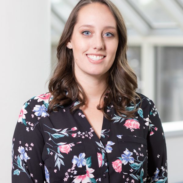 Portrait of Hannah Gish wearing a floral-patterned, button-down shirt.