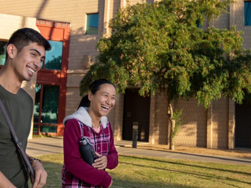 Students walking and laughing on the N A U–Yuma campus.